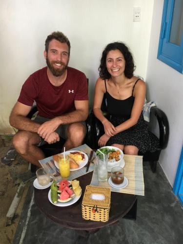 Ein Mann und eine Frau sitzen an einem Tisch mit Essen in der Unterkunft Cashew Tree Bungalow in Hoi An