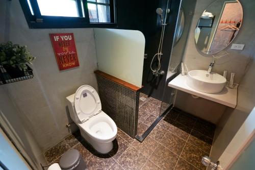 a bathroom with a toilet and a sink at Tobacco Village in Meinong