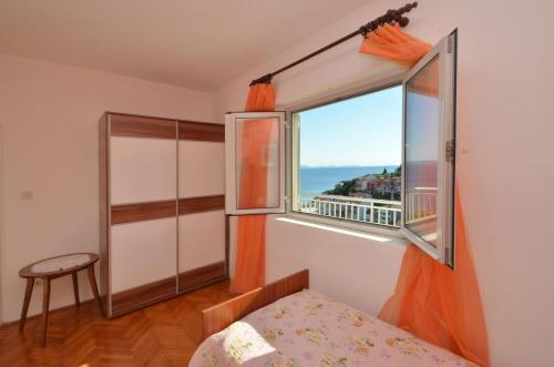ein Schlafzimmer mit Fenster und Meerblick in der Unterkunft Apartments Daniela in Zavalatica