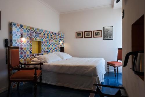 a bedroom with a large bed and a chair at La Moresca in Ravello