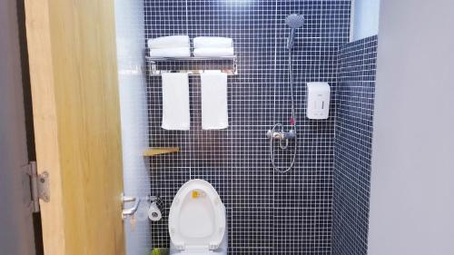 a bathroom with a toilet and a black tiled wall at Fengma Feiyang Hostel in Lhasa