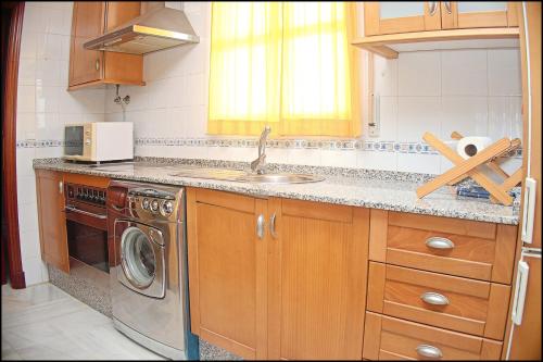 a kitchen with a sink and a washing machine at Apartamento Cruz in Conil de la Frontera