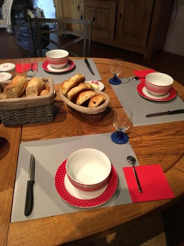 een tafel met borden en kommen en een mand met bagels bij Chez Marydidou : Chambres d'hôtes in Istres