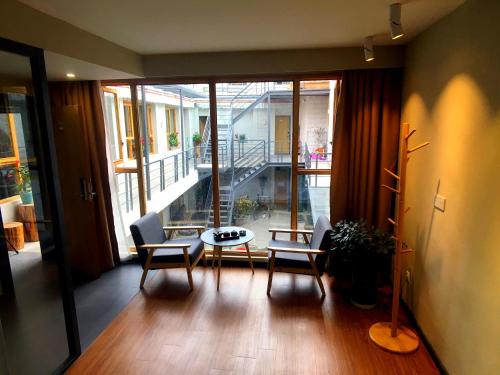 a living room with a table and chairs and a balcony at Fengma Feiyang Hostel in Lhasa