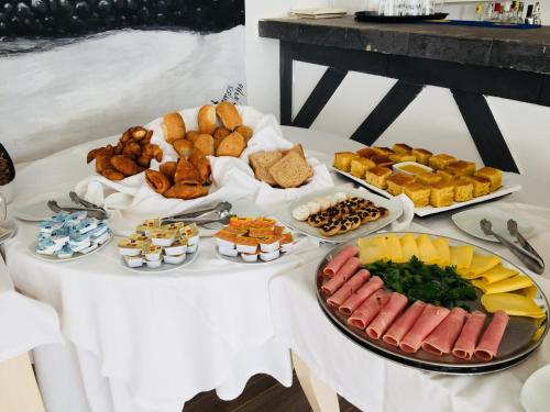 a table topped with different types of bread and food at Hotel LIVVO Budha Beach in Santa Maria