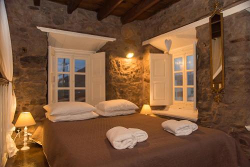 a bedroom with a bed with towels on it at Anemos Houses in Skala