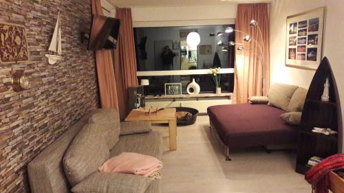 クックスハーフェンにあるFrische Brise Apartments Wagnerのリビングルーム(ソファ、テーブル付)