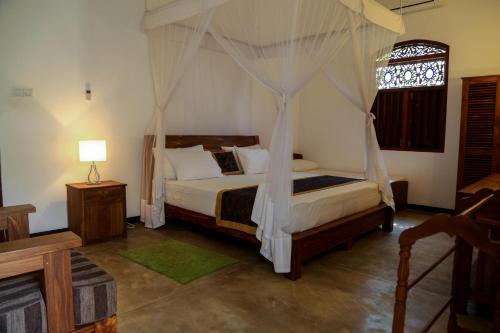 a bedroom with a bed with a canopy at Silver Ferns in Hikkaduwa