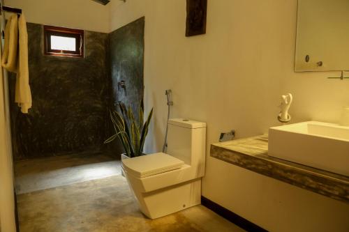a bathroom with a toilet and a sink at Silver Ferns in Hikkaduwa