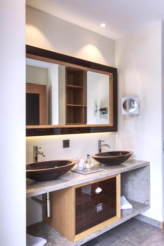 a bathroom with two sinks and a mirror at Hotel Alte Post Bonaduz in Bonaduz