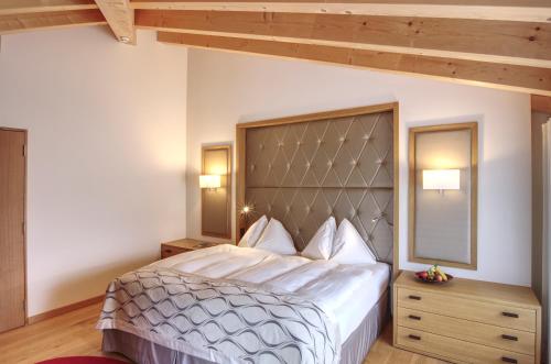 a bedroom with a large bed with a large headboard at Hotel Alte Post Bonaduz in Bonaduz