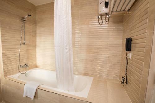 La salle de bains est pourvue d'une baignoire et d'un téléphone. dans l'établissement GSH Colombo, à Colombo