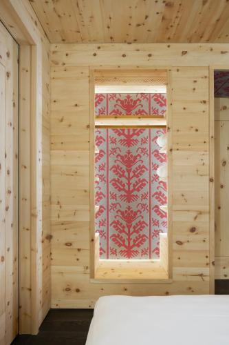 a room with a window in a wooden wall at Alpine Lodge Chesa a la Punt in Pontresina