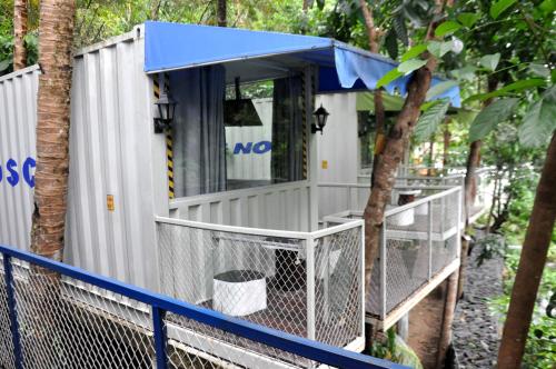 a tiny house with a blue roof and a fence at Hau Eco Lodges Citumang Pangandaran in Pangandaran