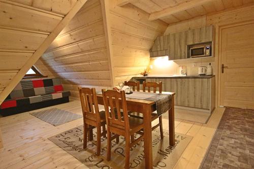 a kitchen and dining room with a table and chairs at Noclegi Brzegi in Brzegi