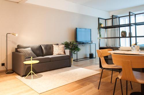 a living room with a couch and a table at PREMIER SUITES Antwerp in Antwerp