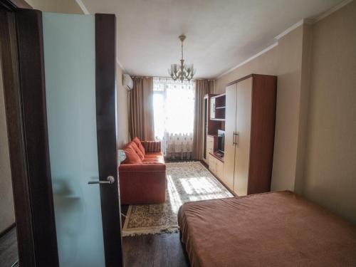 クラスノヤルスクにあるАпартаменты на Молокова 16のベッドルーム1室(ベッド1台、ソファ、窓付)