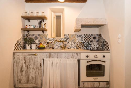 a kitchen with a stove top oven next to a sink at Anemos Houses in Skala