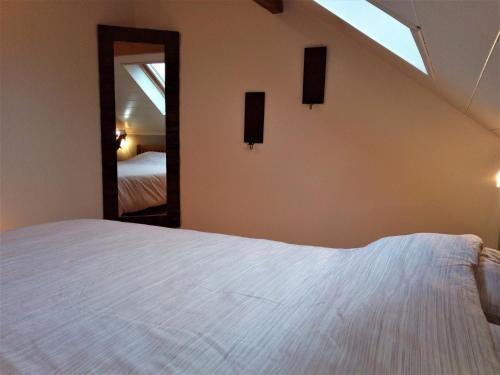 a bedroom with a white bed and a mirror at Point Escale in Lontzen