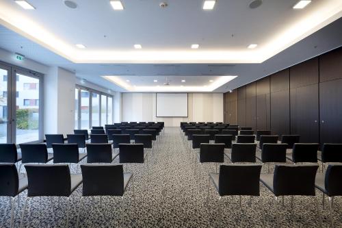 a conference room with chairs and a whiteboard at Eurostars Grand Central in Munich