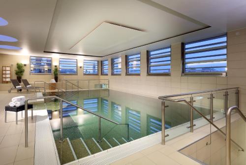 a large swimming pool with a large window at Eurostars Grand Central in Munich