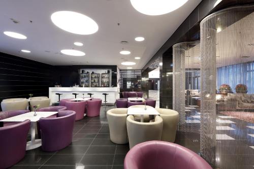 a restaurant with purple and white tables and chairs at Eurostars Grand Central in Munich