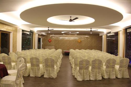a conference room with white chairs and a ceiling at The Brook Resorts & Spa in Yercaud