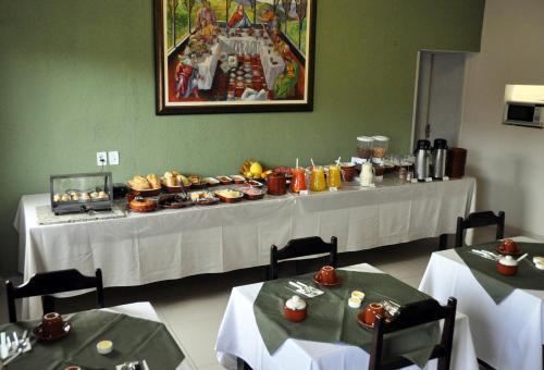 a table with a buffet of food in a restaurant at Hotel Oriente in Itajubá
