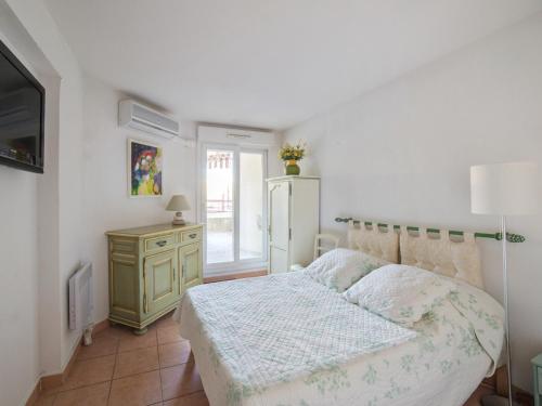 1 dormitorio con 1 cama, vestidor y TV en Welkeys Apartment - Lanterne, en Niza
