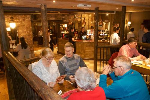 a group of people sitting at a table in a restaurant at Waterloo Cross, Devon by Marston's Inns in Uffculme