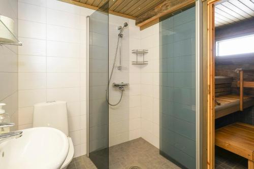 a bathroom with a toilet and a glass shower at Sielikkö Aurora Log Villas in Saariselka