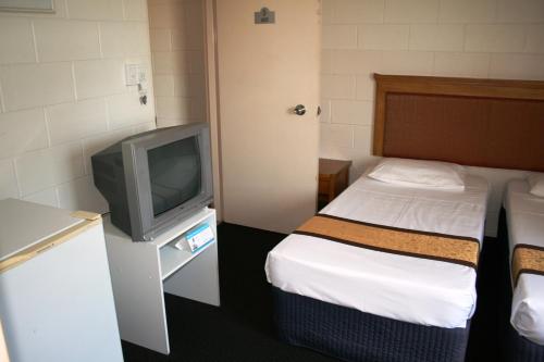 a hotel room with a bed and a tv at Luma Luma Holiday Apartments in Darwin