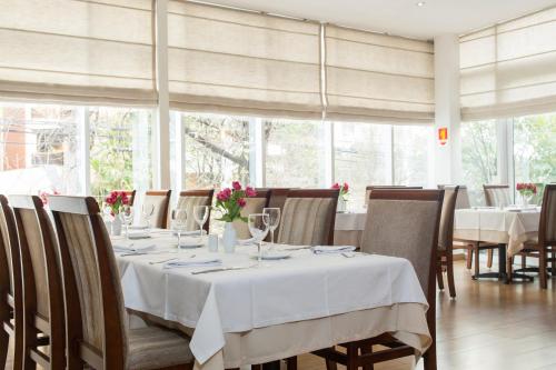 a dining room with a table with glasses and flowers on it at Mercure Sao Paulo Vila Olimpia in São Paulo