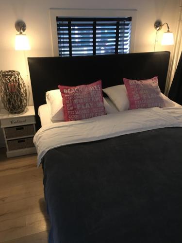 a large bed with red and white pillows on it at Beach House Zandvoort in Zandvoort
