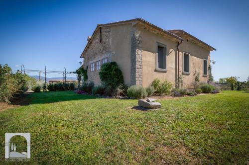 an old house in a field with a yard at Villa Il Nido in Cortona