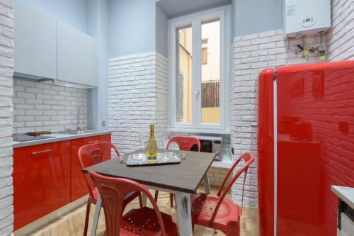 ローマにあるSylvia Stylish Vatican Apartmentのキッチン(テーブル、椅子、赤い冷蔵庫付)