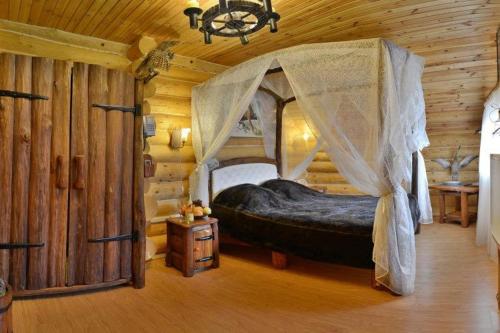 a bedroom with a canopy bed in a log cabin at VVP Club Hotel in Tiraspol