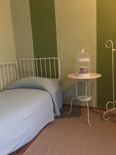 a bedroom with a bed and a bird cage on a table at Agriturismo Cascina Maiocca in Mediglia