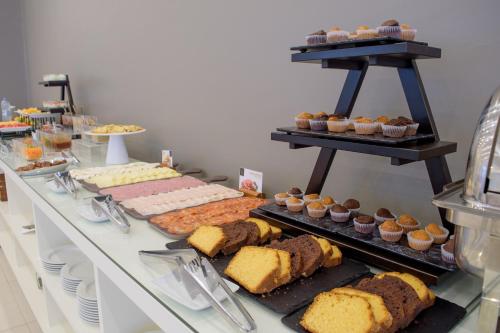 a buffet line with different types of bread and pastries at Oasis Porto Grande in Mindelo