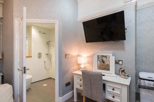 a bathroom with a tv on the wall and a bathroom with a toilet at Marine Studios in Aberystwyth