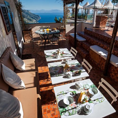 a row of tables with plates of food on a balcony at La Moresca in Ravello