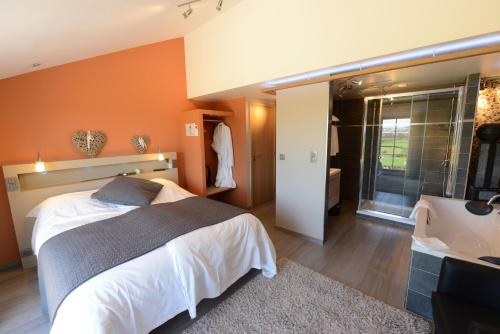 a bedroom with a bed and a bathroom with a sink at Les Coteaux du Vinave in Herve