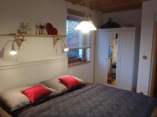 a bedroom with a bed with two red pillows on it at Apartmany Bublava 817 in Bublava