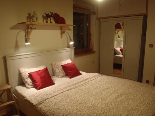 a bedroom with a bed with two red pillows at Apartmany Bublava 817 in Bublava