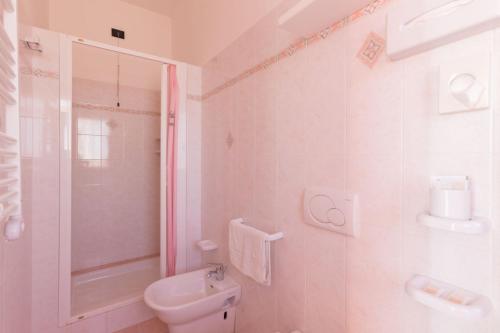 a white bathroom with a toilet and a shower at Hotel Biancaneve Wellness in Marotta