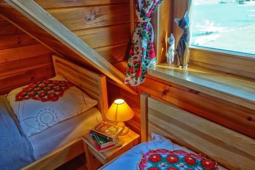 a small room with a bed and a lamp and a window at Agroturystyka Żabi Raj Serock - Pułtusk in Pokrzywnica