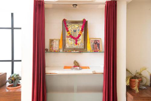 a shelf in a room with red curtains at Hotel Vaikunth By Adamo in Nāthdwāra