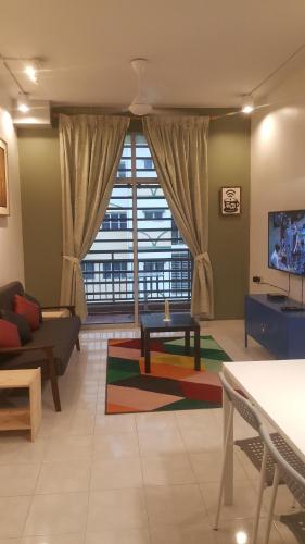 a living room with a couch and a large window at Tulip Hotel in Ipoh