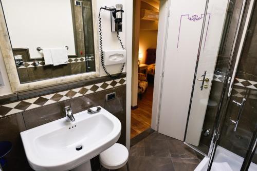 een badkamer met een wastafel en een douche bij Hotel Posta in Moltrasio