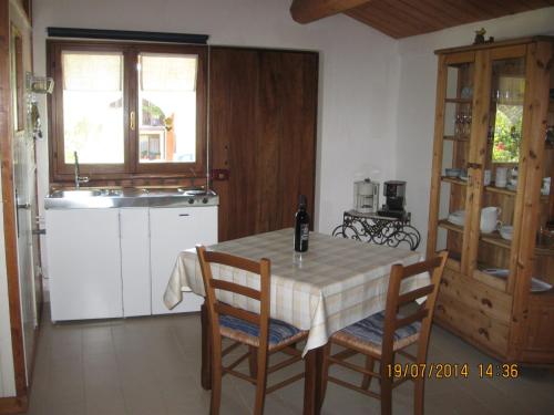 - une cuisine avec une table, des chaises et un évier dans l'établissement La Mia Piccola Casetta, à Arcevia